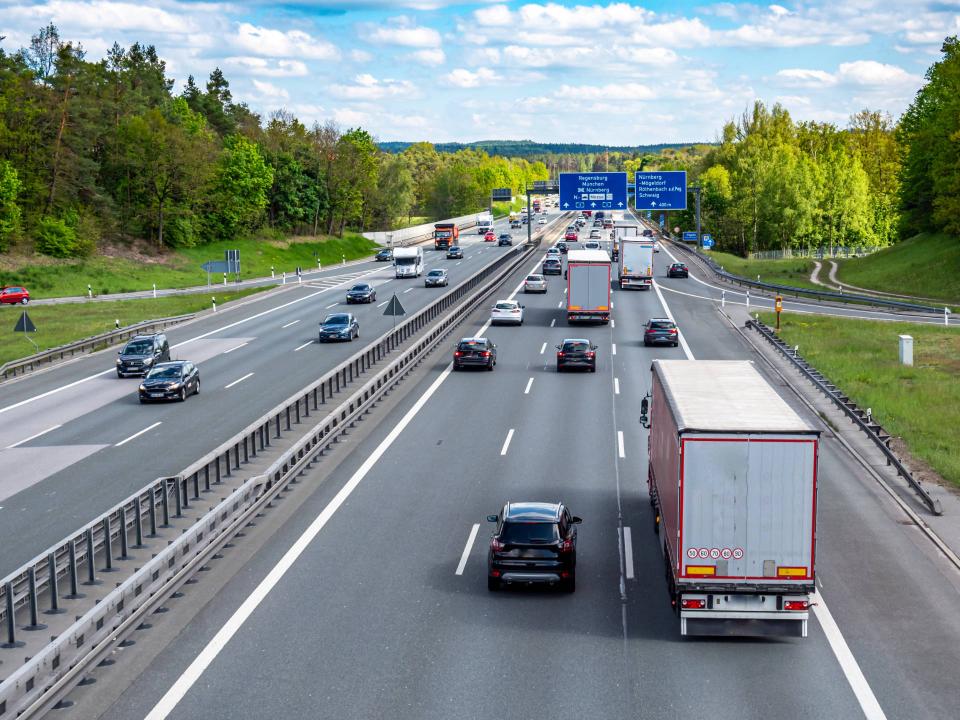 Autos und Lkws fahren dicht gedrängt auf einer Autobahn____