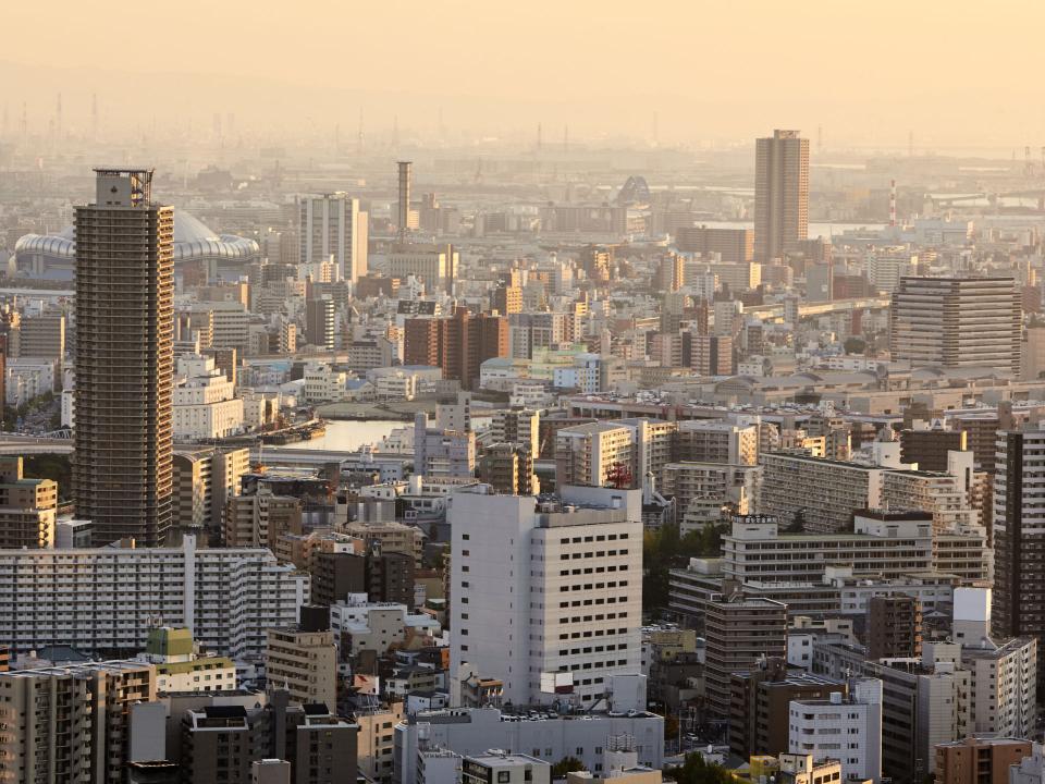 Panoramablick auf Osaka bei Sonnenuntergang, mit zahlreichen Wohn- und Bürogebäuden vor der Skyline____