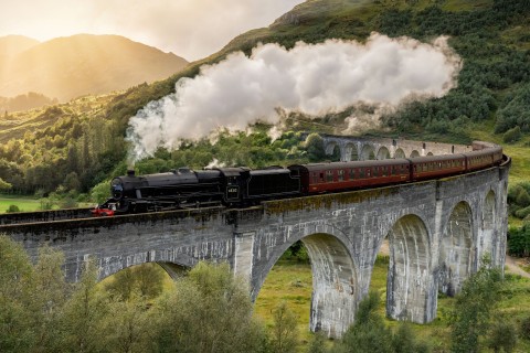 Schottlands wilde Landschaft erlebt man am besten aus dem Zugfenster der West Highland Railway Line. Das Glenfinnan Viadukt wurde durch die Harry-Potter-Filme weltberühmt. Foto: Adobe Stock