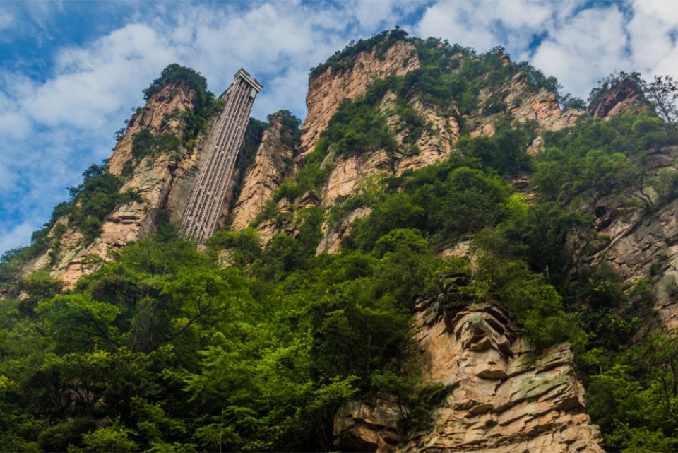 Der Bailong-Aufzug ist wahrlich spektakulär. In zwei Minuten bringt der höchsten Outdoor-Lift der Welt seine Fahrgäste auf ein Felsmassiv aus Sandstein. Foto: Adobe Stock
____
