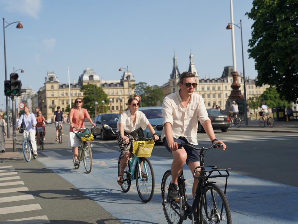 Gruppe von Radfahrern überquert eine Straße in der Stadt.____