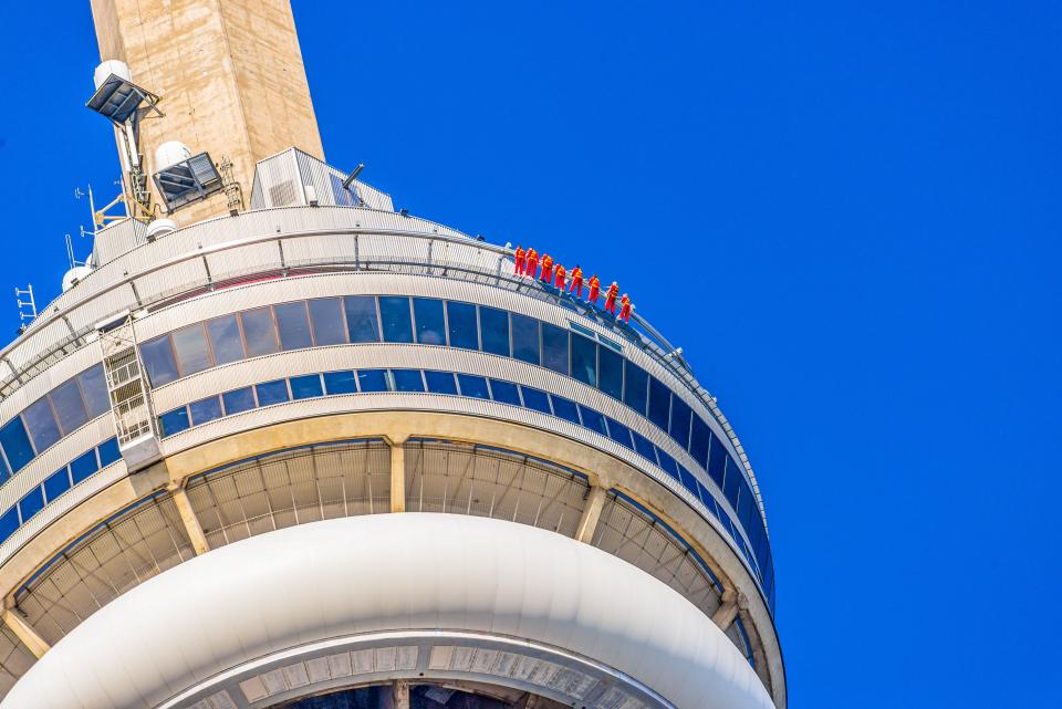 Beim "Edge Walk" umrunden die Wagemutigen in Anzügen und Klettergeschirr die offene Spitze des 356 Meter hohen CN Tower von Toronto. Foto: AdobeStock____