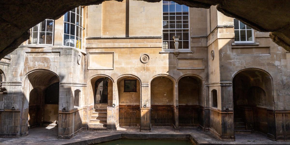 Außenfassade der Thermen mit Wasserbecken im Vordergrund.