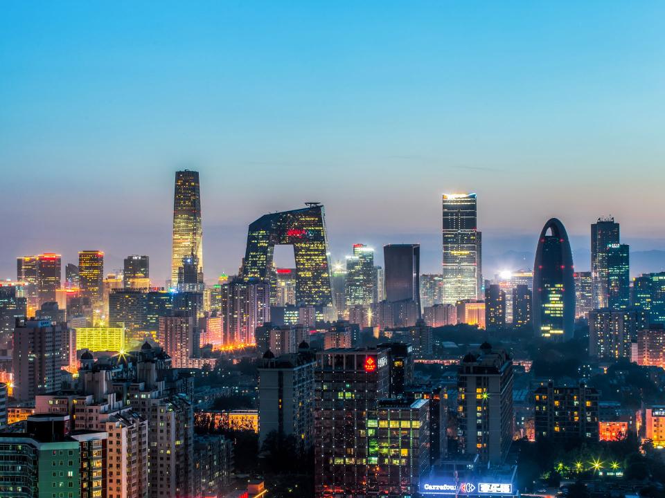 GPT Panoramablick auf die beleuchtete Skyline von Peking bei Abenddämmerung, mit modernen Wolkenkratzern wie dem CCTV-Gebäude____