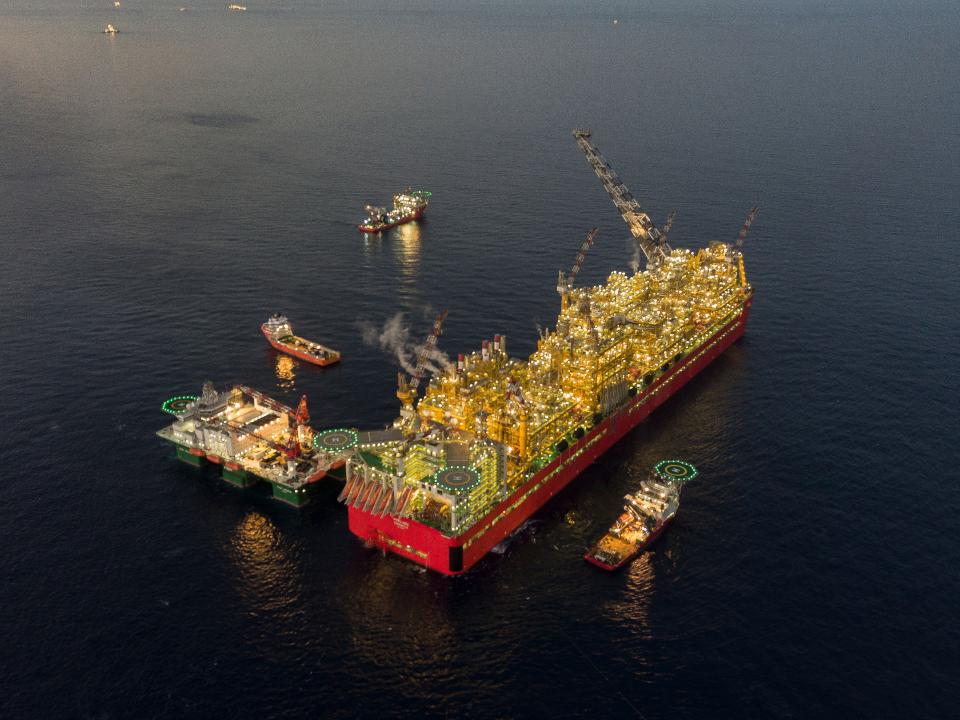 Das schwimmende Bauwerk Prelude FLNG leuchte in der Dämmerung____