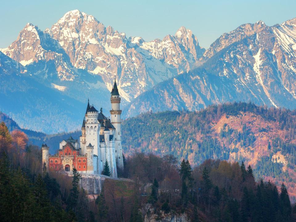 Schloss Neuschwanstein mit hohen Türmen vor schneebedeckten Bergen.____