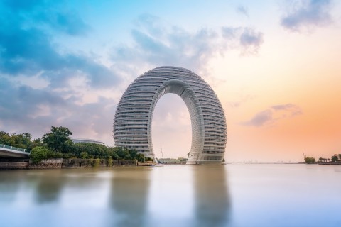 Das Sheraton Hot Spring Resort in Huzhou soll von tradtionellen chinesischen Brücken inspiriert worden sein – sieht aber eher aus wie ein riesiges Hufeisen. Foto: Adobe Stock