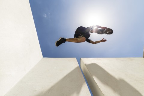 Ein Mann springt in Sportkleidung über Mauern.
