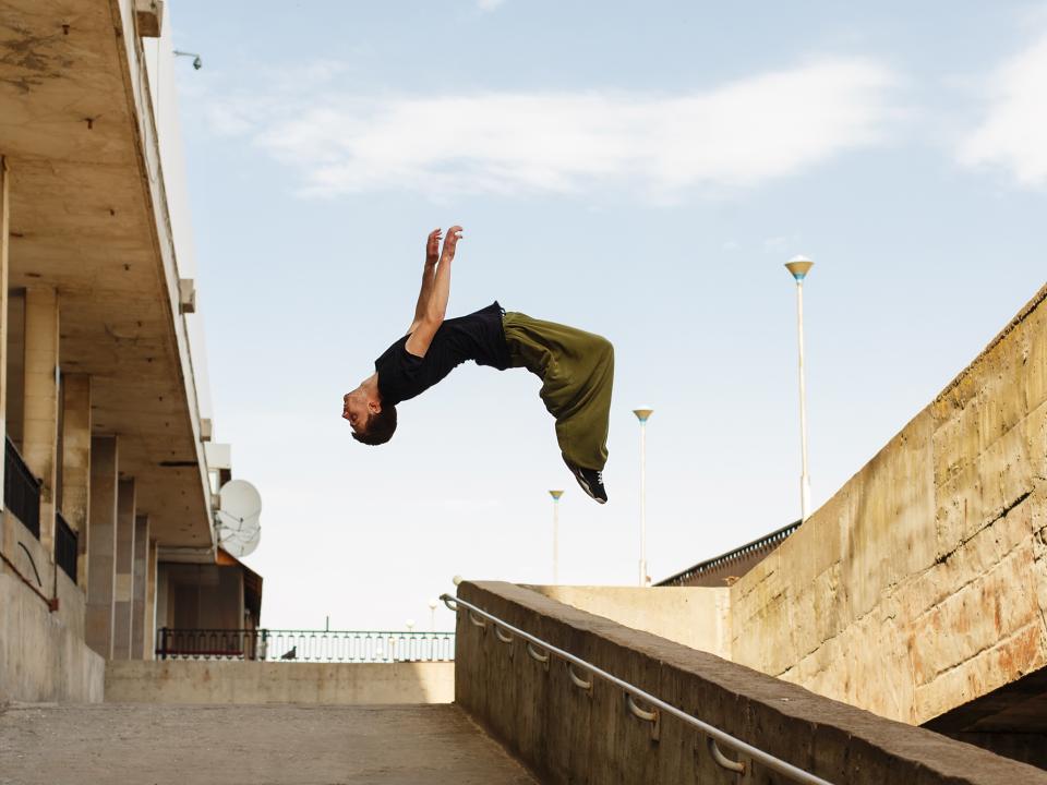 Ein Parkour-Künstler vollführt Tricks im städtischen Gbiet.____