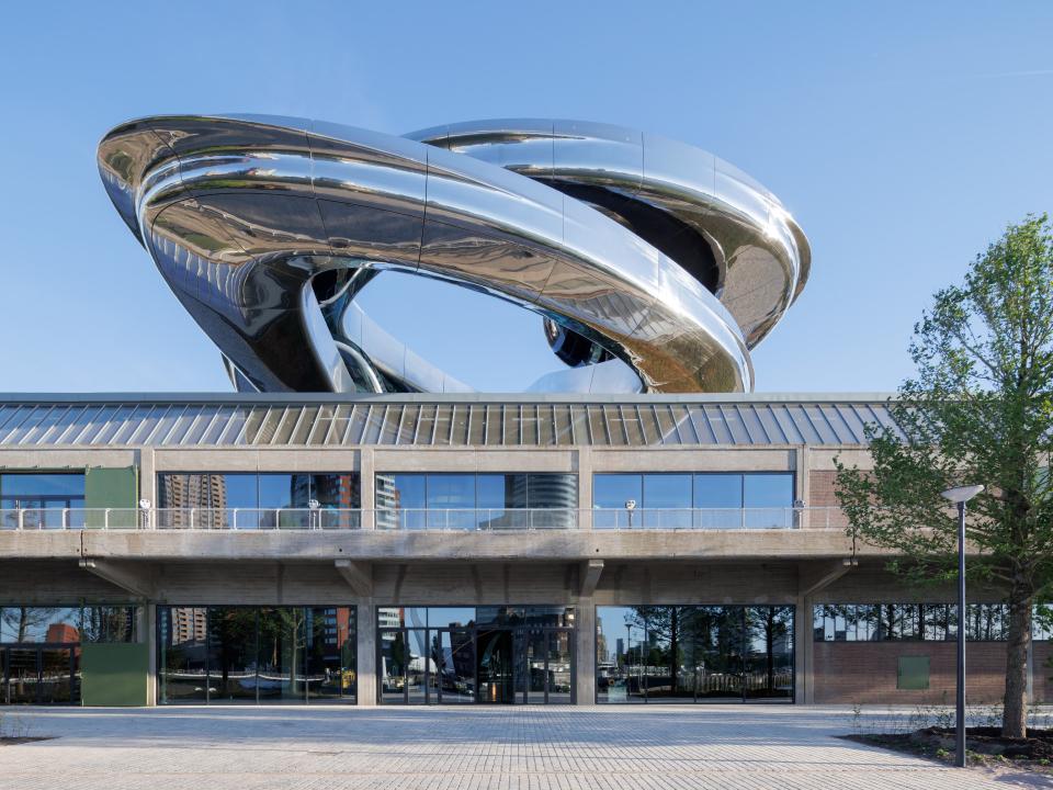 uturistisches Gebäude mit glänzender Edelstahlstruktur auf Betonsockel, modernes Architektur-Museum.____