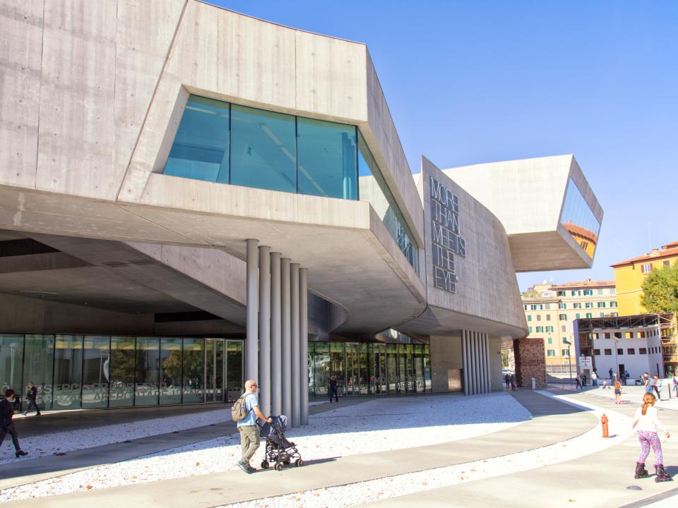 MAXXI Museum in Rom mit schrägen Betonflächen und modernen Glasdetails in urbaner Umgebung.____