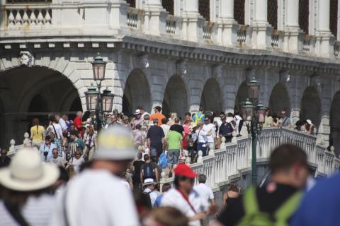 Menschenmenge drängt sich auf venezianischer Promenade, Basilika Santa Maria della Salute im Hintergrund.