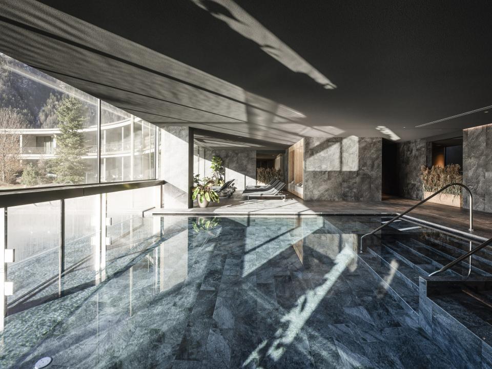 Luxuriöser Innenpool mit großen Fenstern und Bergblick, stilvolles Design.____