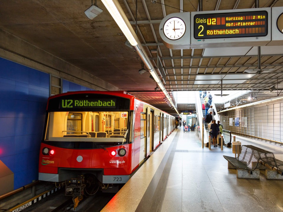 An einem U-Bahnhof in Nürnberg fährt eine rote autonom fahrende U-Bahn ein, es ist eine U2 nach Röthenbach, durch ihre Frontscheibe sieht man direkt den Fahrgastbereich.____
