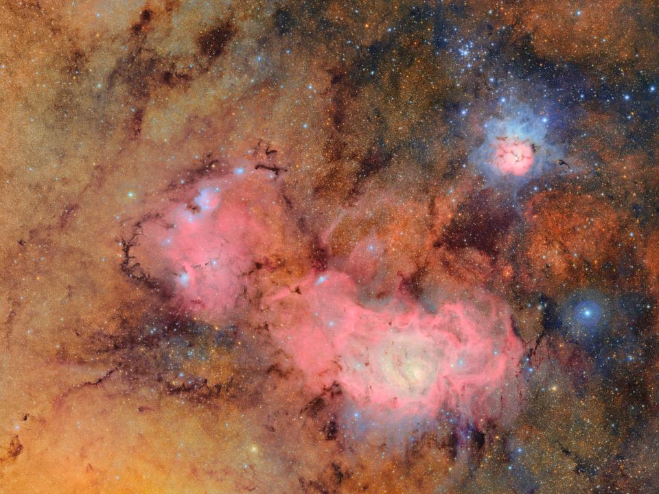 Emissionsnebel mit rötlichen Gaswolken und blauen Sternentstehungszonen im All____