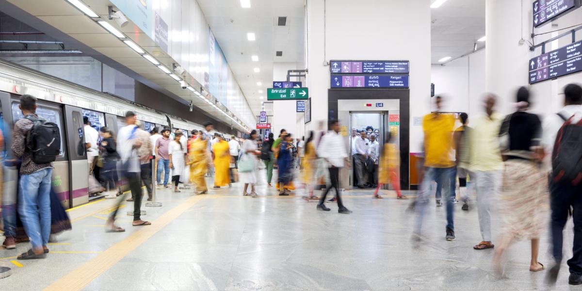 Belebte U-Bahn-Station mit Menschen in Bewegung und einfahrendem Zug.