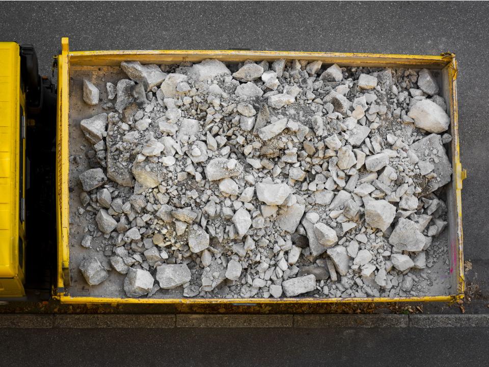 Gelber Lkw mit Steinschutt beladen, Luftaufnahme.____