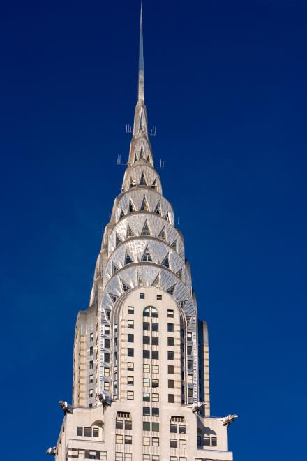 Das Chrysler Building mit seiner ikonischen, spitzen Art-déco-Krone aus Edelstahl vor einem klaren blauen Himmel