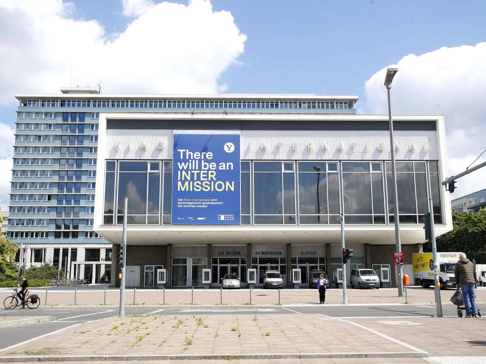 Frontansicht des Kino International in Berlin mit moderner Fassade und großem Banner über Renovierungsarbeiten.____
