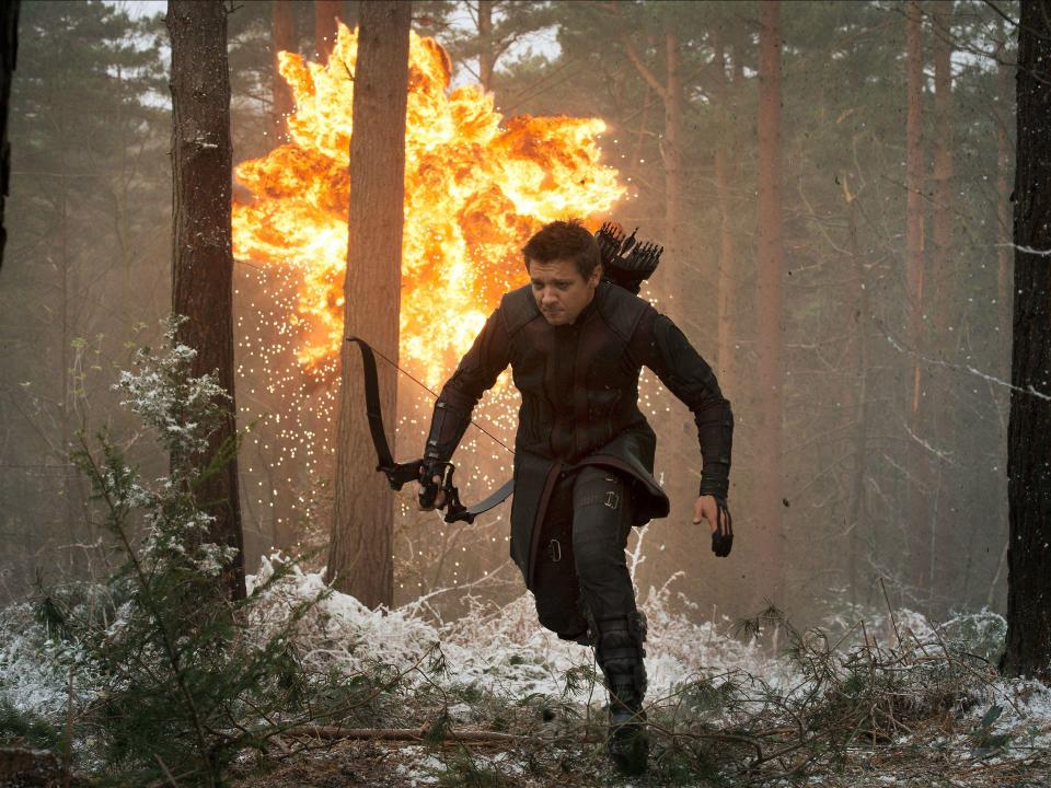 Bogenschütze in schwarzer Rüstung rennt durch Wald, Explosion im Hintergrund.____