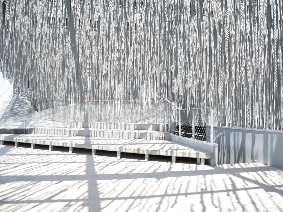 Helle, lichtdurchflutete Terrasse mit hängenden weißen Strukturen, modern und luftig.____