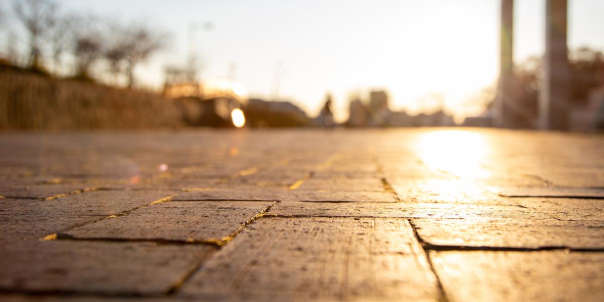 Flacher Blick auf gepflasterten Boden bei Sonnenuntergang mit unscharfem Hintergrund.