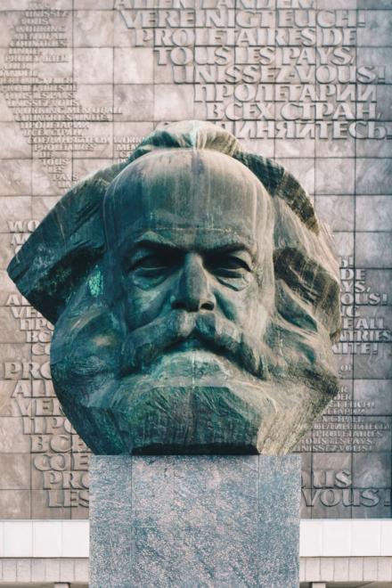 Großes Denkmal von Karl Marx aus Bronze mit Inschrift in mehreren Sprachen im Hintergrund