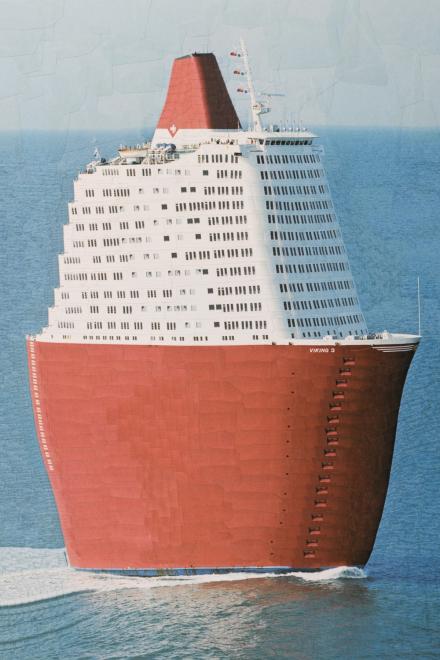 Riesiges Kreuzfahrtschiff mit architektonisch wirkendem Aufbau, der an ein Hochhaus erinnert.