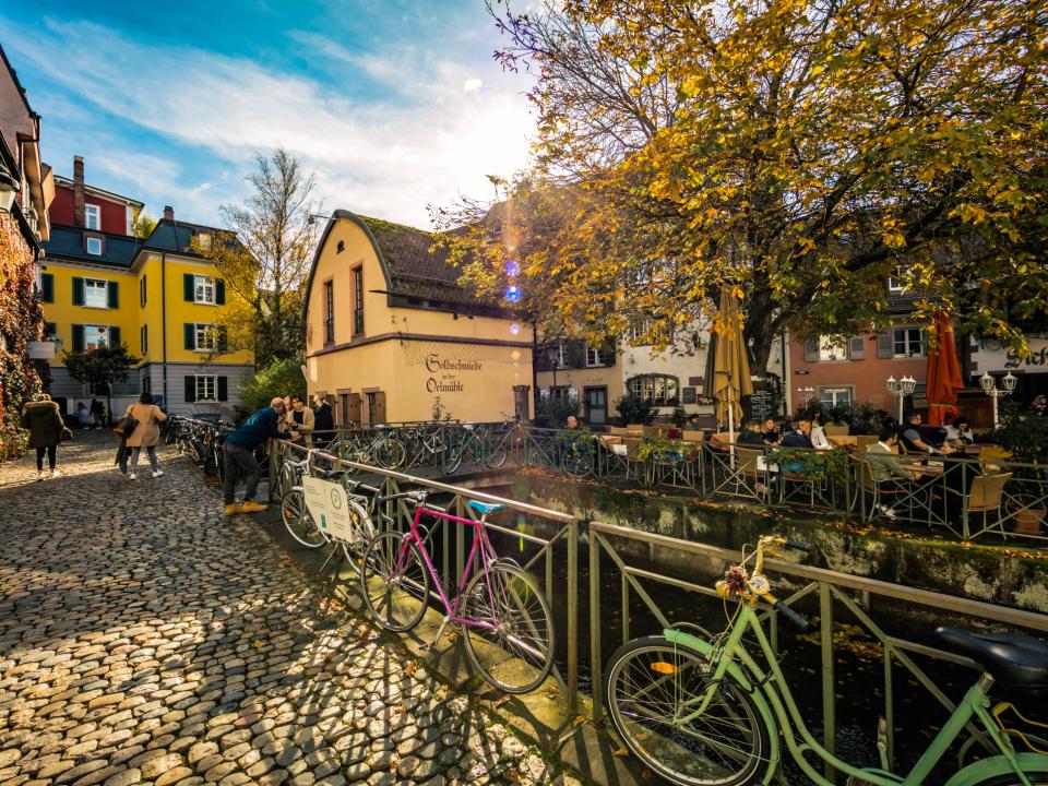 Gemütlicher Straßencafé an einem Fluss in einer Altstadt im Herbst.____
