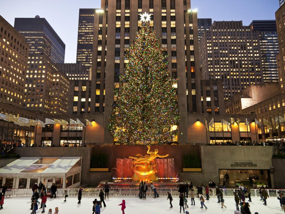 Eislaufbahn vor dem Rockefeller Center mit geschmücktem Weihnachtsbaum und beleuchteten Gebäuden.____