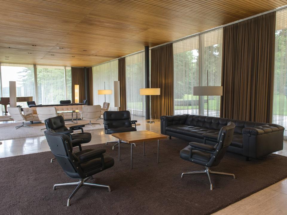 Modern eingerichteter Lounge-Bereich mit Ledersesseln, Sofas und Holzdecke im minimalistischen Stil.____