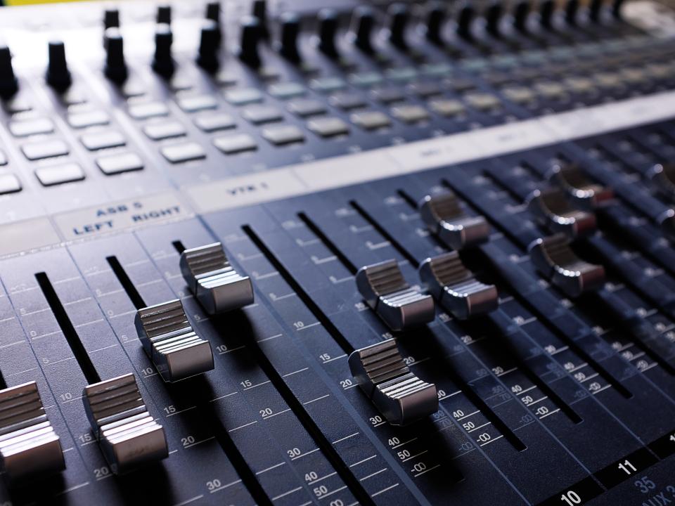 Nahaufnahme eines Mischpults mit Metall-Fadern, professionelles Audio-Equipment im Tonstudio.____