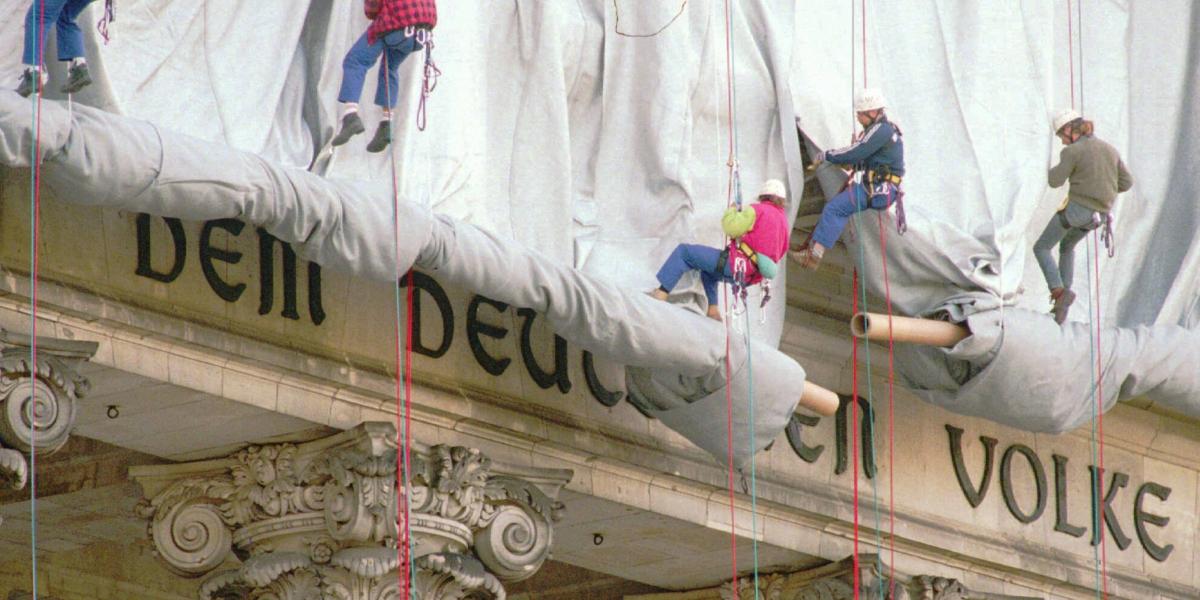 Arbeiter mit Seilen montieren silbernen Stoff an Säulen des Reichstags, teils sichtbare Inschrift „Dem Deutschen Volke“
