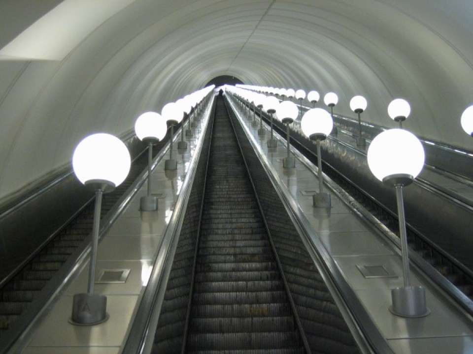 Rolltreppe in einer U-Bahn-Station. Lichtkugeln befinden sich zwischen den jeweiligen Rolltreppen____