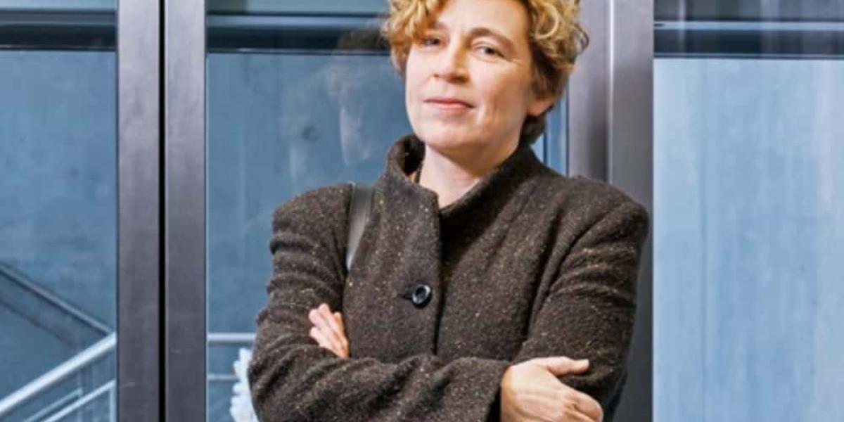 Dr. Babette Renneberg im Porträt. Sie verschränkt ihre Arme und lächelt leicht