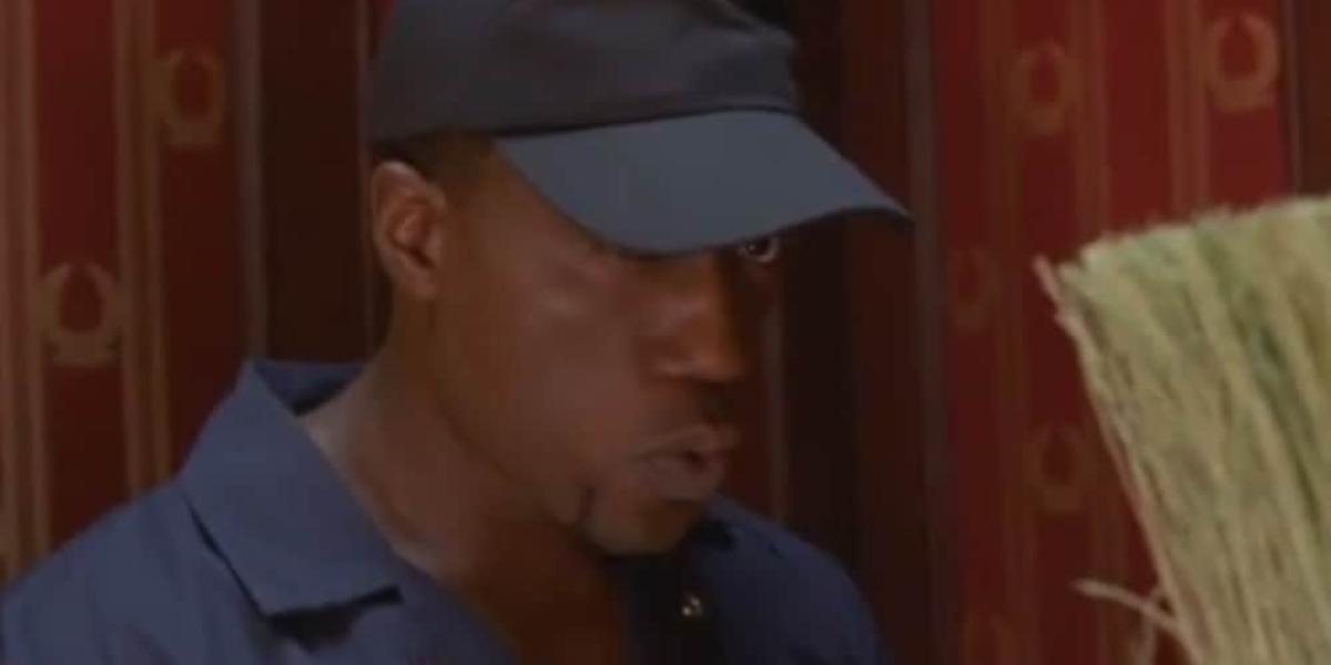 Mann im Blaumann und blauer Cap schaut verstohlen in die Ferne und pfeift.