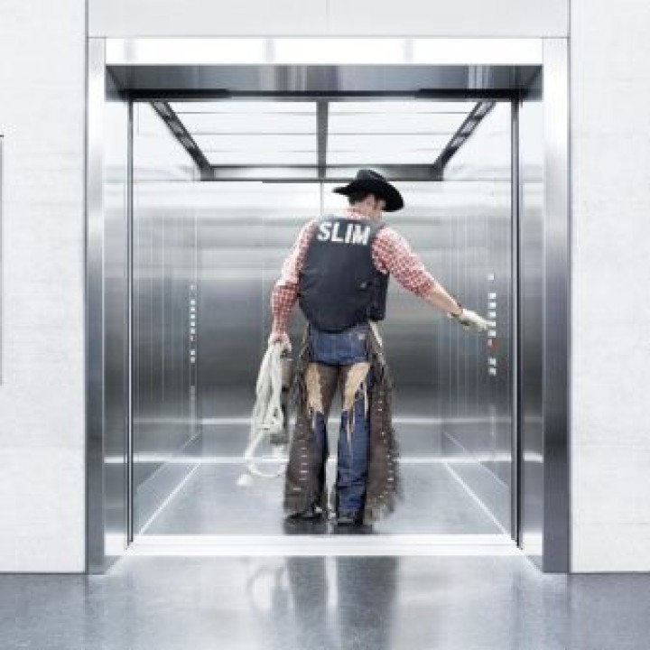 Ein Cowboy betritt einen modernen Fahrstuhl____
