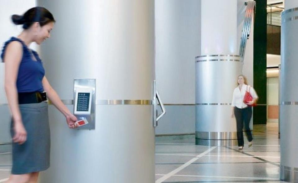 Eine Frau hält eine Checkkarte vor einem Terminal____