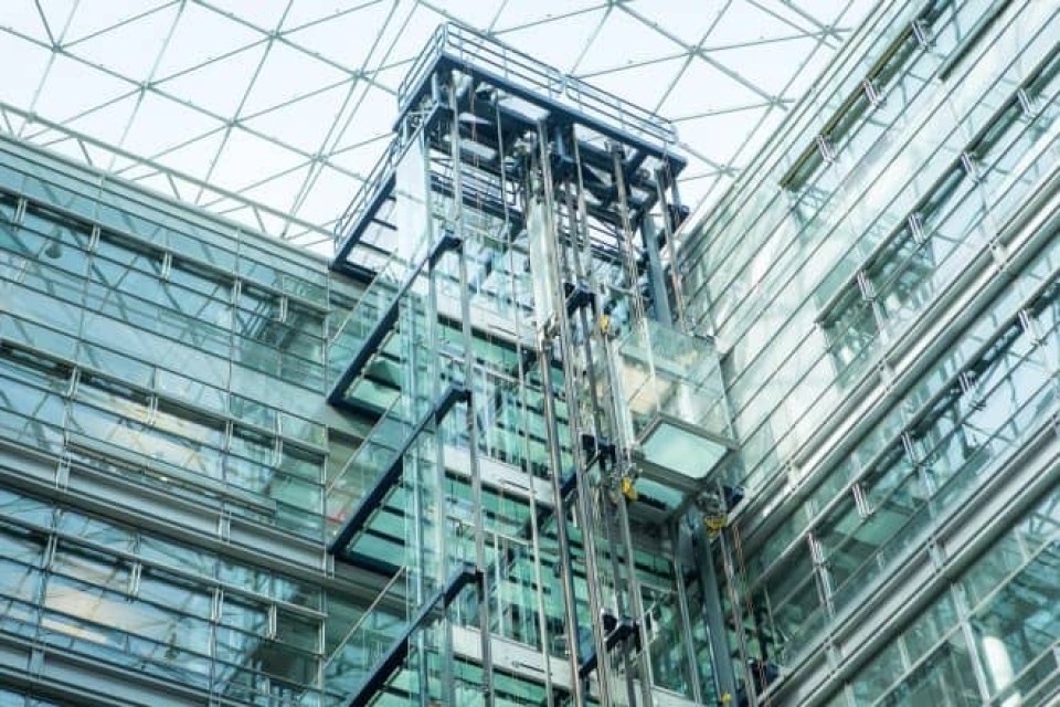 Ein gläserner Aufzug in einem gläsernen Gebäude____