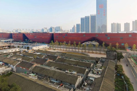Wie ein Riegel schiebt sich das Kulturzentrum in Shenzhen zwischen die umliegende Bebauung. © Mecanoo