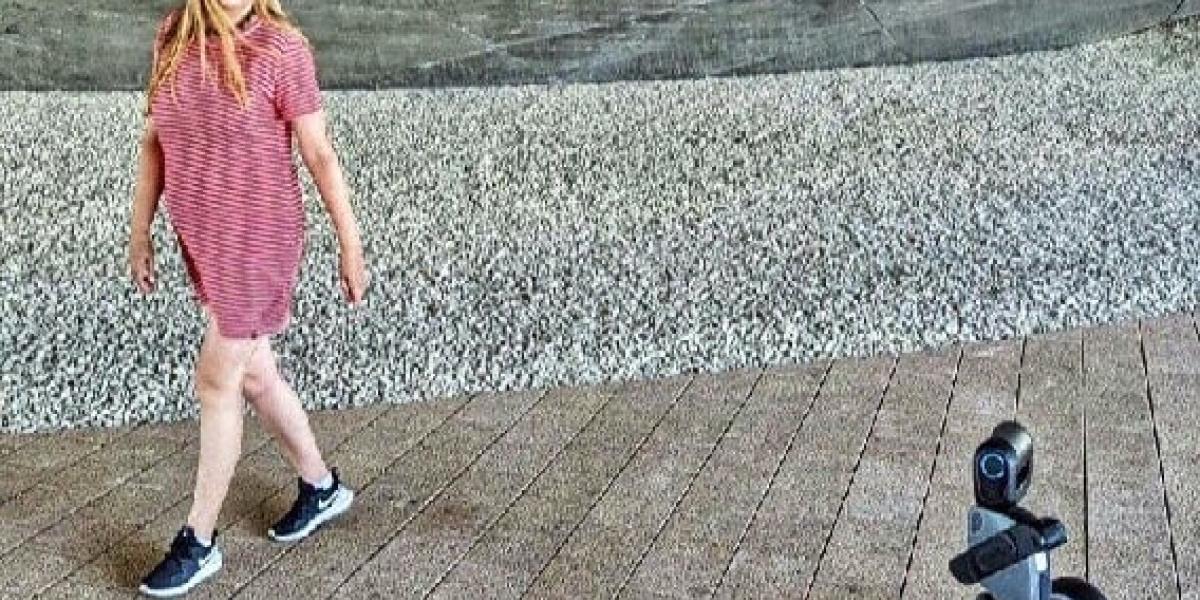 Frau in rotem Kleid mit fahrenden Roboter im Vordergrund