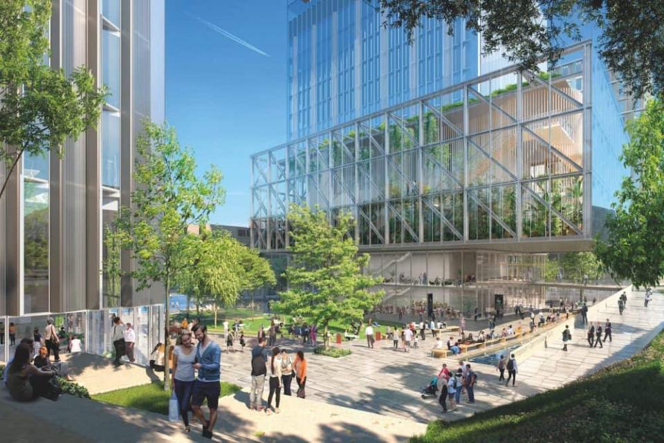 Grüner, heller Innenhof mit vielen sitzenden und Steheden Menschen. Gebäude aus Glas stehen um das Plaza herum.____