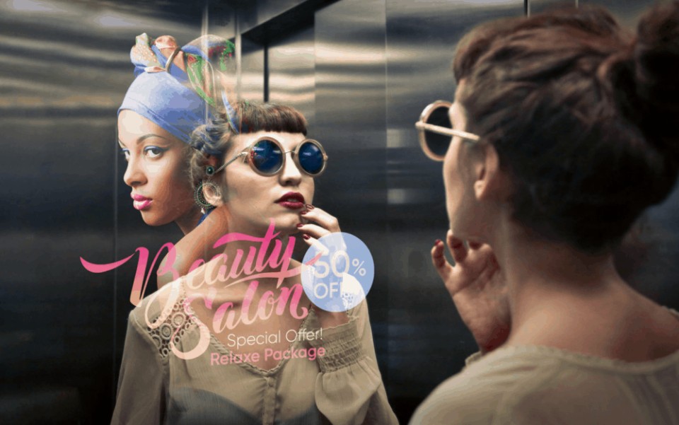 Eine Frau mit großer runder Sonnenbrille, roten Lippenstift und schaut in einem Fahrstuhl in den Spiegel. Sie bemüht mit ihren Finger die Lippen, um ihr Make-Up zu checken.____