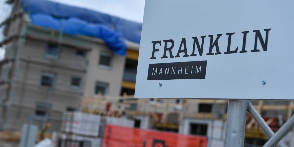 Projekt-Schild mit der Aufschrift Franklin Village im Vordergrund einer Baustelle